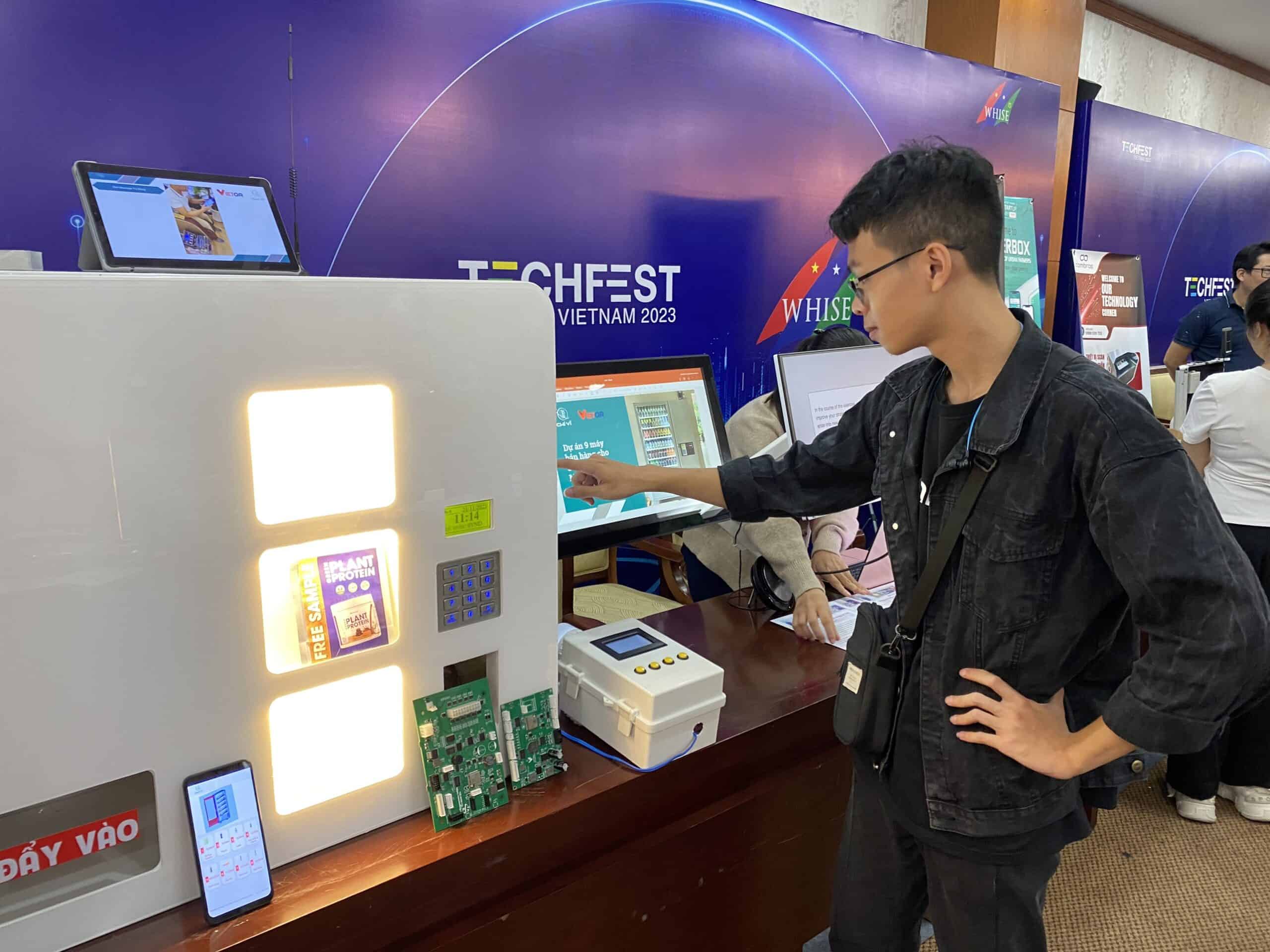 Khách tham quan tìm hiểu thông tin về công nghệ thanh toán QR code trên máy bán hàng tự động Chí Vĩ